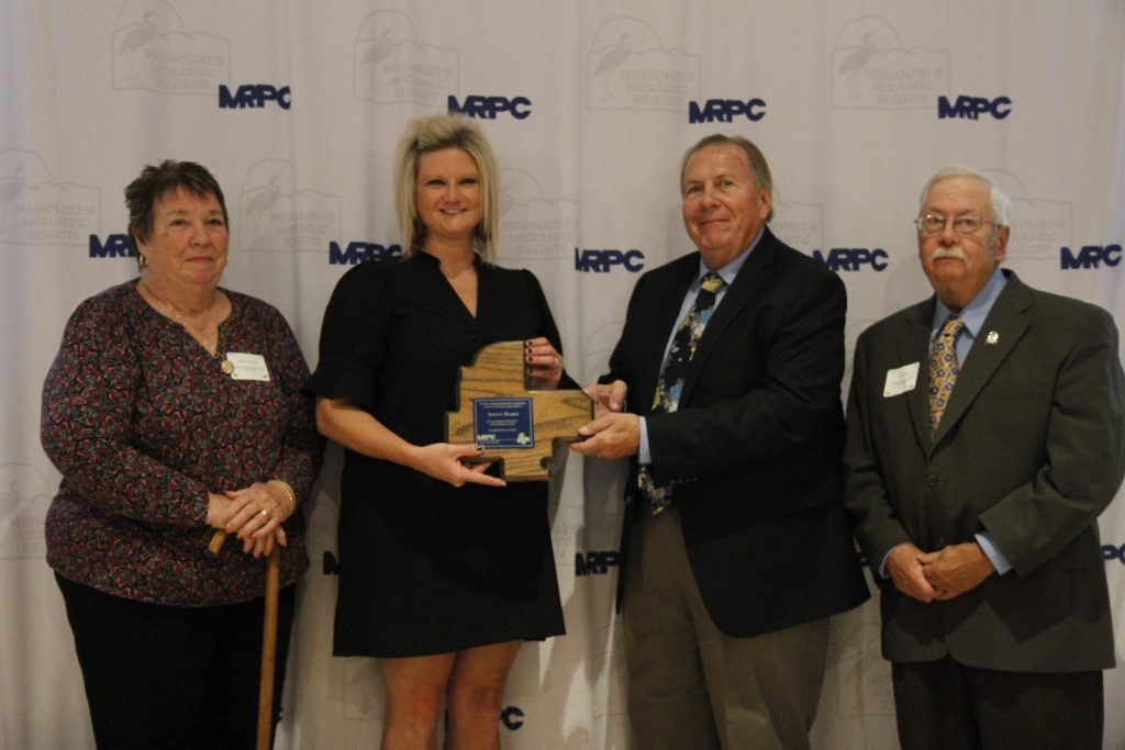 Ashley Harris of Belle was presented with an Outstanding Community Service Award , by MRPC Board Chair Mary Heywood (left) and Vice Chair Darryl Griffin (second right) at the 2024 Annual Dinner and Awards Banquet on Oct. 24 in Linn. Sanders was nominated by MRPC Board Member Steve Vogt (right), who represents Belle.