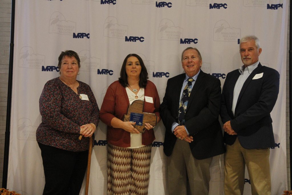 Tracy Staples was presented with an Outstanding Community Service Award by MRPC Board Chair Mary Heywood (left) and Vice Chair Darryl Griffin (second right) at the 2024 Annual Dinner and Awards Banquet on Oct. 24 in Linn. She was nominated by Crawford County Presiding Commissioner Steve Black (right). 